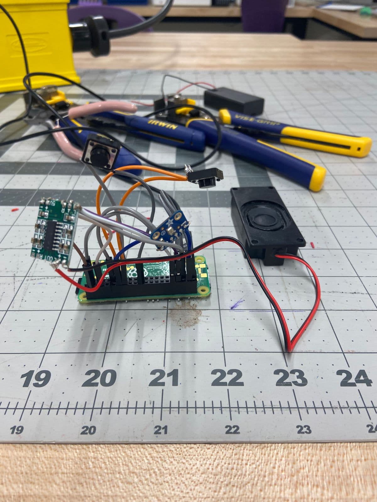 The bee prototype on a workbench: a Raspberry Pi Zero, an audio amp board, a speaker, a microphone, and wiring.